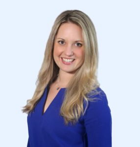 Sonja Fridell wearing a blue blouse and a dainty necklace.