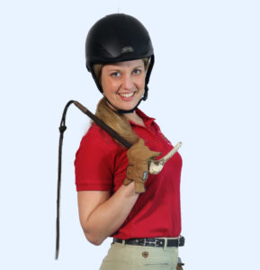 Sonja Fridell wearing a red polo shirt and a black helmet while holding a whip.