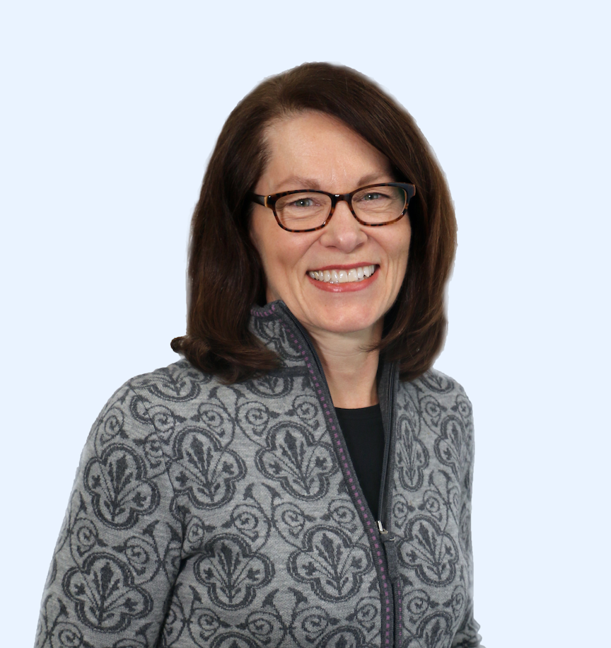 Theresa Conway wearing a gray patterned jacket and black framed glasses.