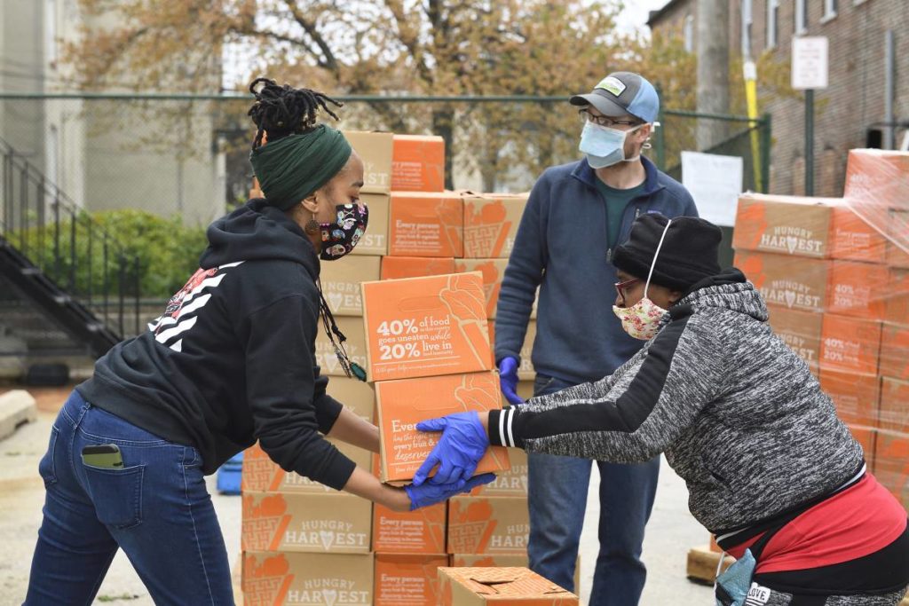 Saval Food Service Workers hand food boxes off